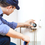 smiling technician repairing an hot water heater