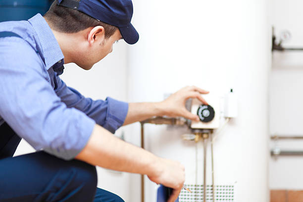 smiling technician repairing an hot water heater