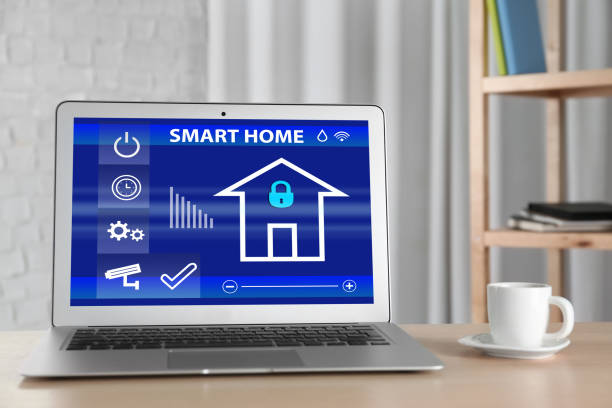 modern laptop with home security app on table indoors